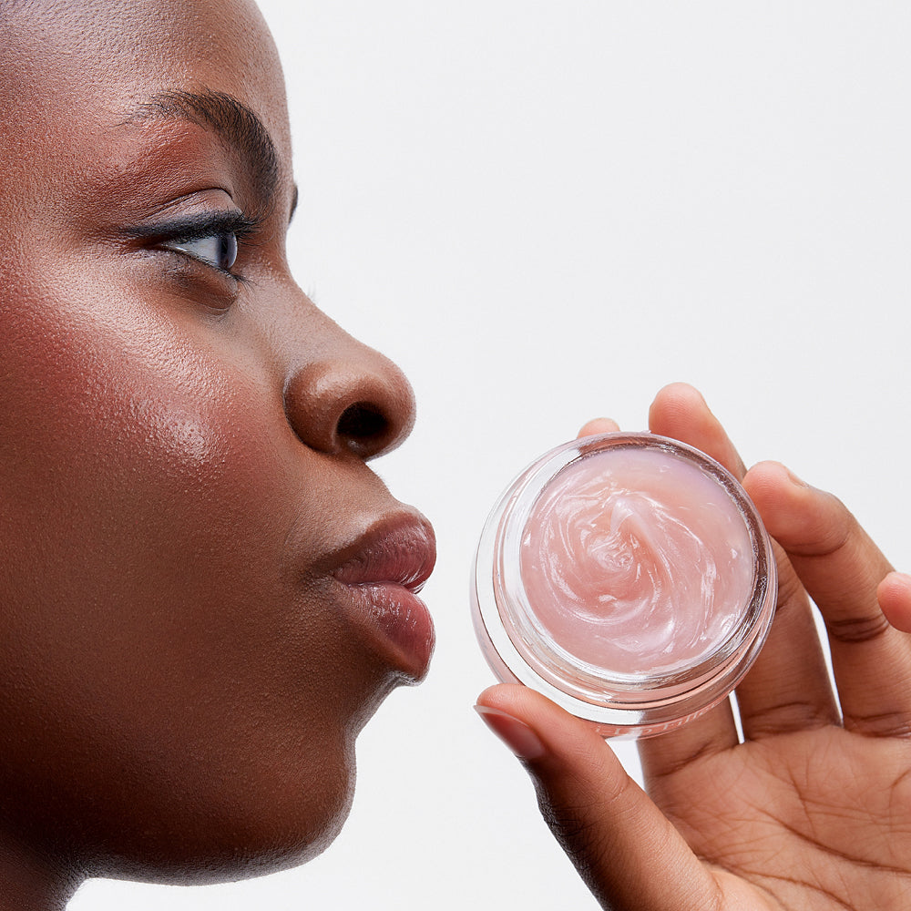 image mood of model holding glossy lip line eraser next to her full lips.